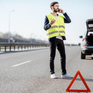 Man calling road assistance on the highway